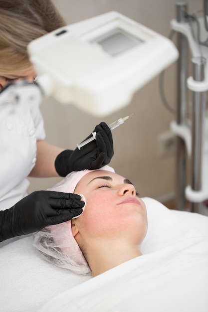 Closeup of cosmetologist doctor making antiaging injections of a young girl