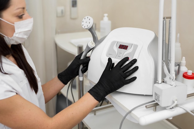 Closeup of a cosmetologist includes a mesotherapy medical device