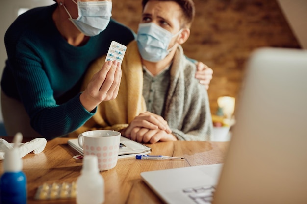 Closeup of a couple talking about medicines with their doctor via video call during coronavirus pandemic