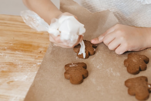 Closeup cropped shot of female hands holding icing decorating gingerbread cookies Preparing for Christmas New Year