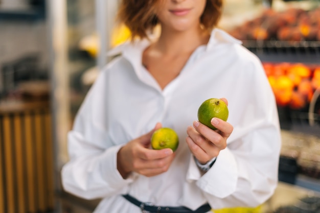 Closeup cropped shot of unrecognizable young woman holding in hands lime posing standing at fruit