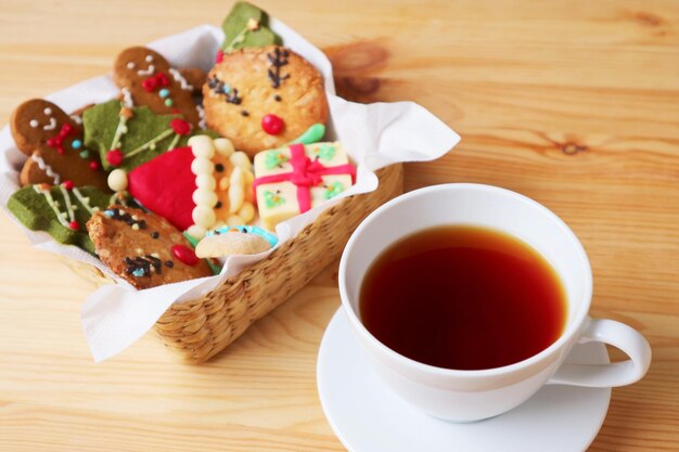 Photo closeup a cup of hot tea with blurry basket of christmas cookies in the backdrop