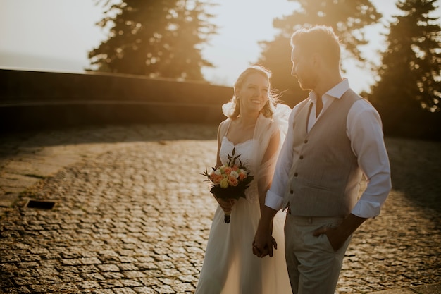 Closeup of the cute young newlywed couple walking in the park