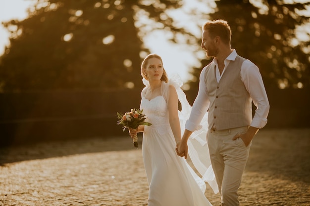 Closeup of the cute young newlywed couple walking in the park