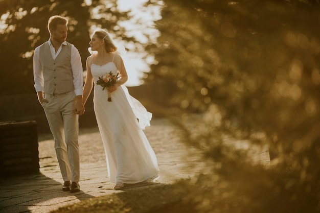 Closeup of the cute young newlywed couple walking in the park