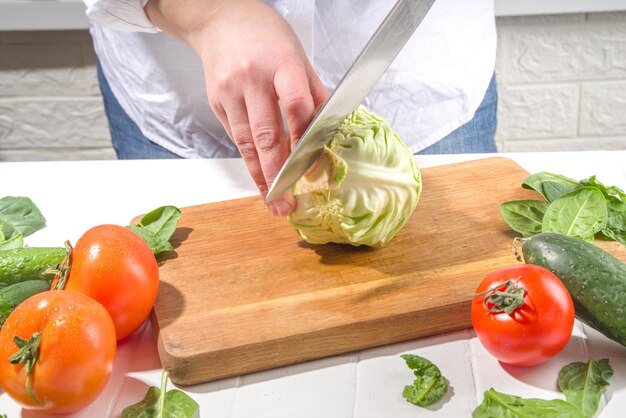 Closeup of cutting slicing fresh cabbage Womans hands cut with knife fresh cabbage vegetables