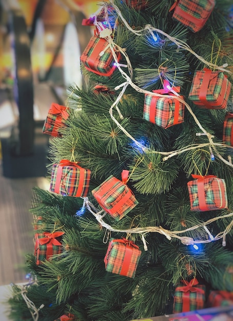 Closeup of Decorated Christmas tree with bright red balls on blurred sparkling background.