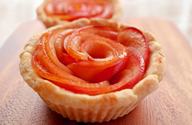 Closeup of Delectable Fresh Baked Rose Shaped Apple Tartlet on Wooden Breadboard