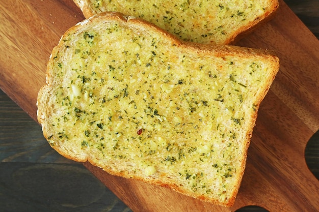 Closeup of Delectable Freshly Cooked Homemade Garlic Butter Toast on Wooden Breadboard