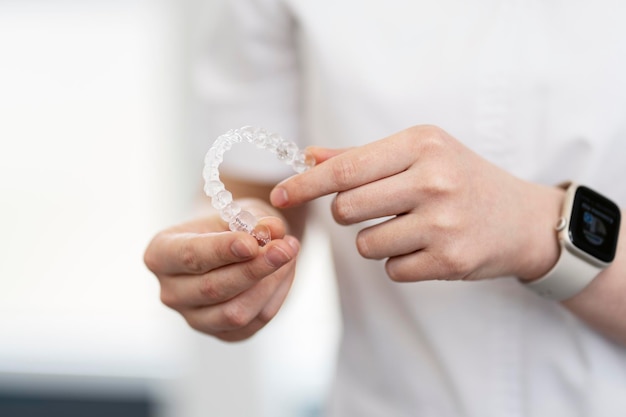 Closeup of a dentist holding an aligner in his hands Modern teeth alignment technologies in orthodontics