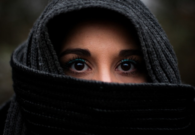 Closeup of the detail of the open eyes of a veiled woman made up