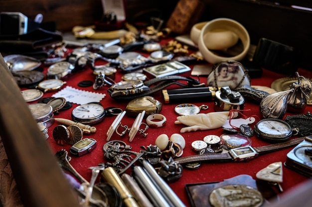 Photo closeup of different vintage watches and jewelry on a red surfa