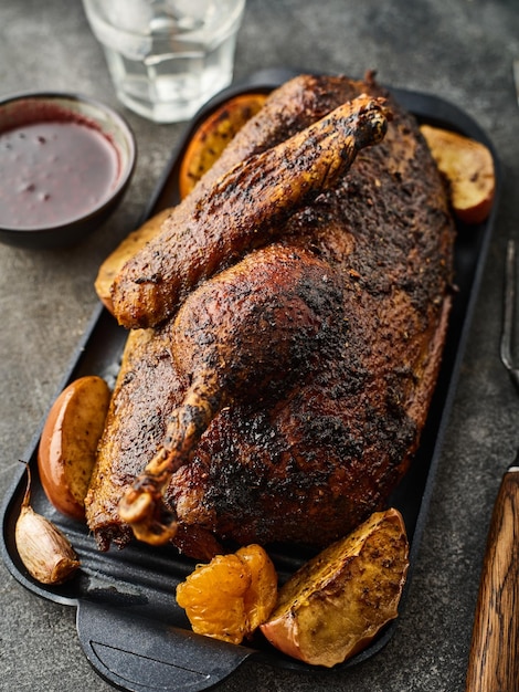 Closeup of a dish of baked duck stuffed with apples The duck is baked with apples and served on a plate on a table