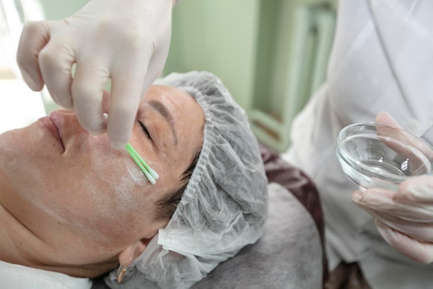 Closeup doctor cosmetologist applies a treatment solution for skin rejuvenation