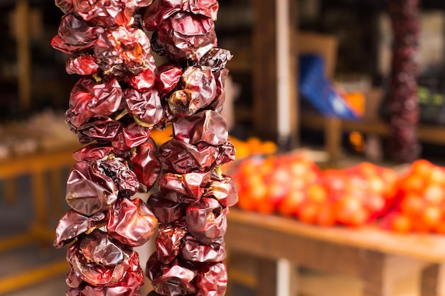 CloseUp of dried red peppers hanging on a rope in the market