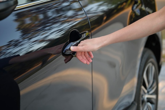 Closeup of driver hand opening car front door with touch ID finger imprint scanning technology Vehicle safety concept