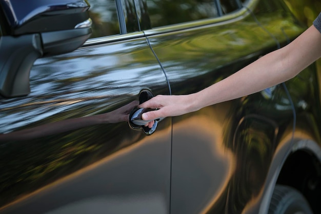 Closeup of driver hand opening car front door