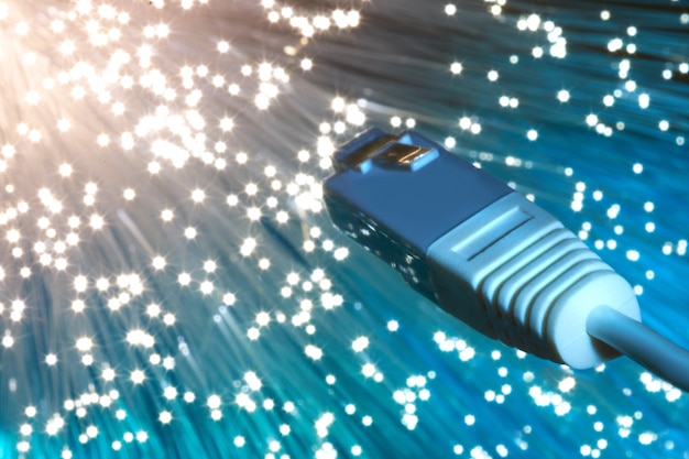 Closeup on the end of optical fiber network cable on blue