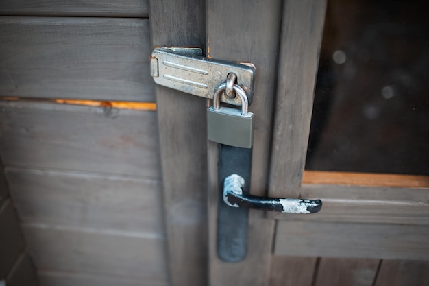 Closeup of exterior padlock and old handle of wooden door