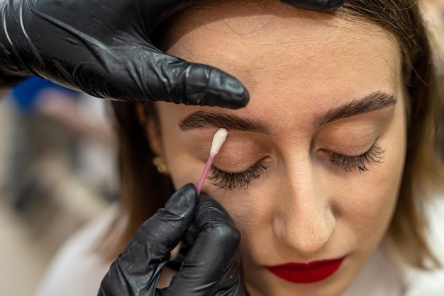 Closeup of an eyebrow designer correcting and touching up eyebrows