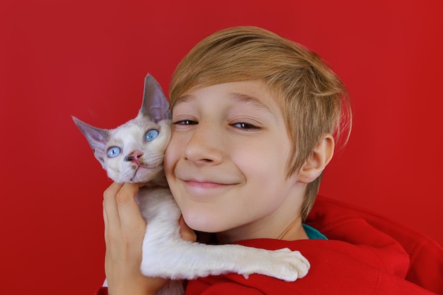 Closeup of the face of a boy who hugs a white cat with blue eyes