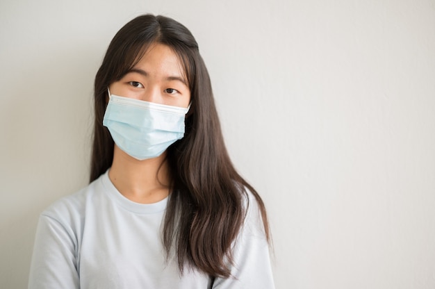 Closeup face portrait Female university Asian students wear a mask and keep social distances during school hours.