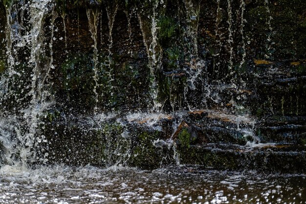 Closeup of falling and splashing streams of water Ivande waterfall Latvia