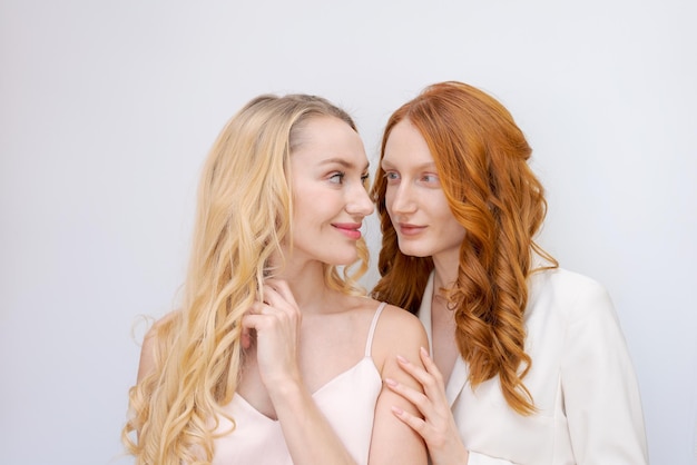 Closeup fashion portrait couple of two pretty women best friends smiling