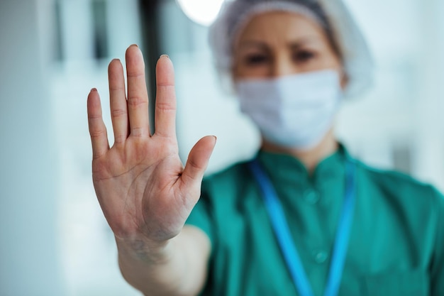 Closeup of female doctor gesturing to stop while working at the hospital during coronavirus epidemic