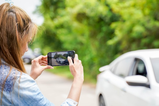 Closeup female driver are using mobile phones to take photos as evidence for insurance claims