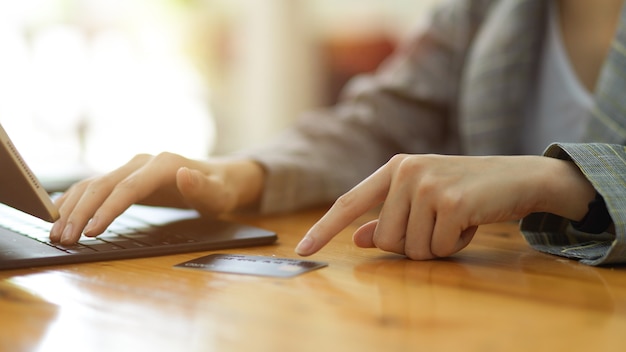 Closeup female entering credit card number by using on digital tablet online payment banking