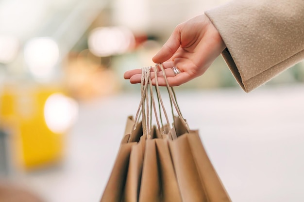 Photo closeup of female hand holding kraft paper bag isolated