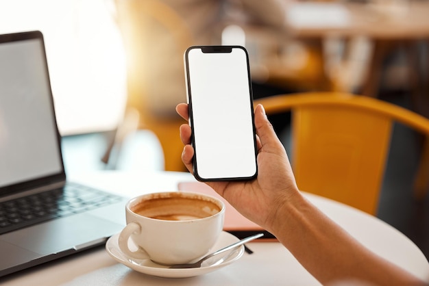 Closeup of a female hand holding phone with copy space while sitting in a modern coffee shop Woman working on technology browsing on the internet social media or an online website at a cafeteria