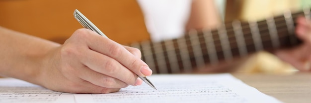 Closeup of female hand writing notes of new song new ideas inspirational singer composing music