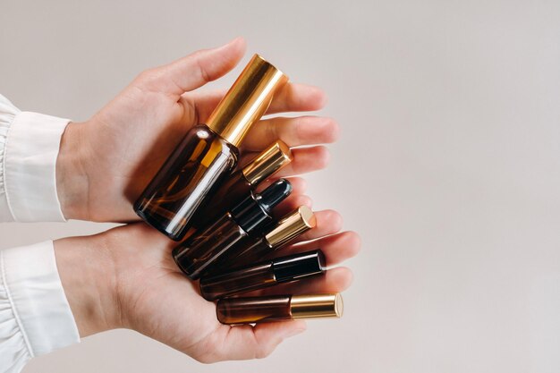 Closeup of female hands holding many bottles of essential oil Aromatherapy