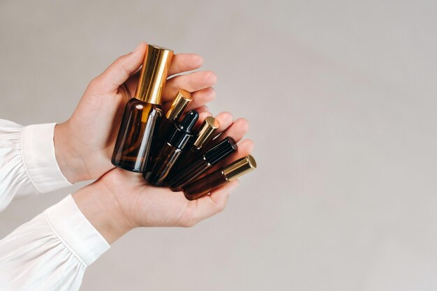 Closeup of female hands holding many bottles of essential oil Aromatherapy