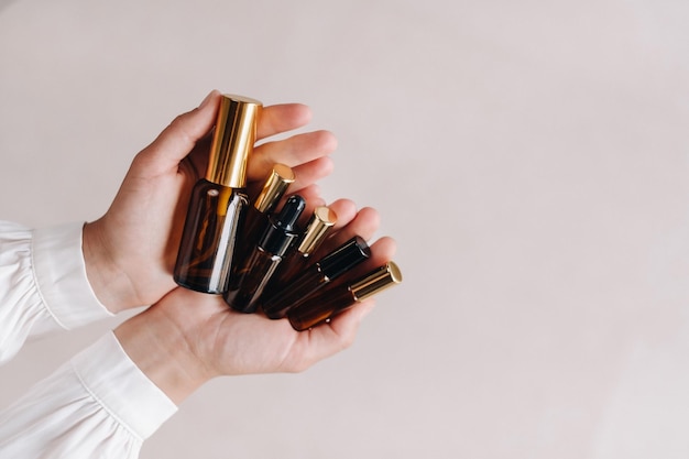 Closeup of female hands holding many bottles of essential oil Aromatherapy