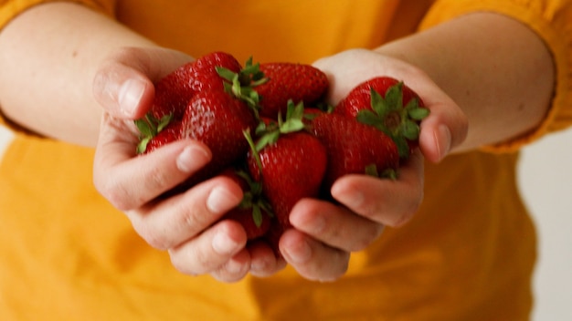 Closeup of female hands holding ripe juicy strawberries