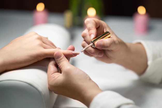 Closeup of female hands during manicure routine at nail studio