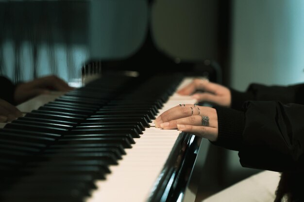 Photo closeup of a female hands playing a grand piano