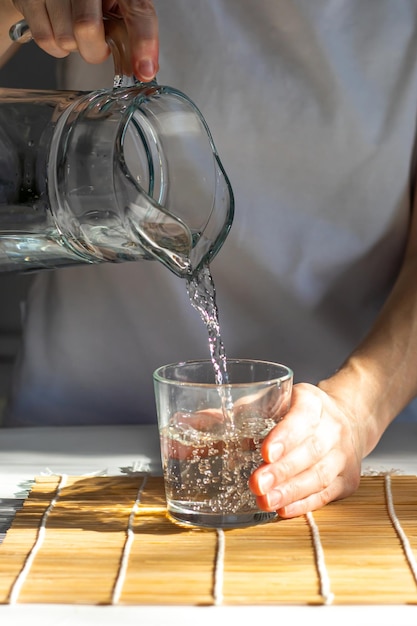 Closeup of female hands pouring drinking water into a glass morning rituals for health