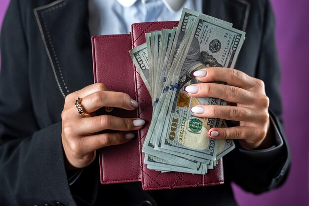 Closeup of female hands putting a dollar bill in her purse