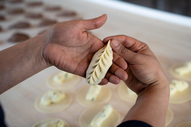 Closeup of female hands showing fresh homemade culurgiones pasta Italian typical filled pasta from Sardinia region