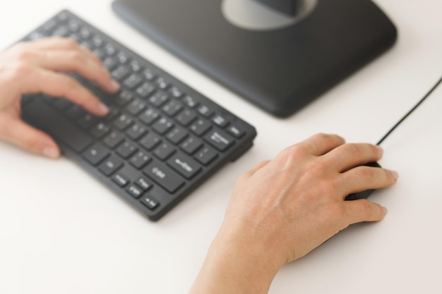 Closeup of female hands using computer pc on workplace in office