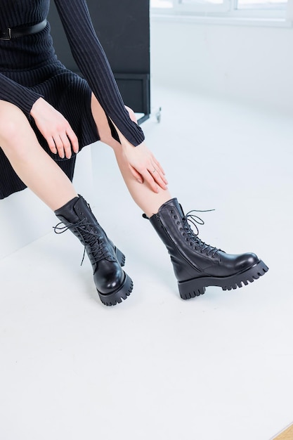 Closeup of female legs in black leather laceup boots Women's comfortable spring casual shoes Black women's spring boots