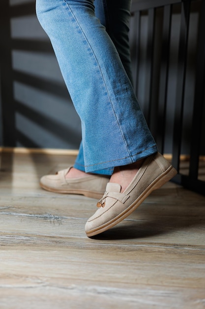 Closeup of female legs in jeans and beige loafers made of genuine leather