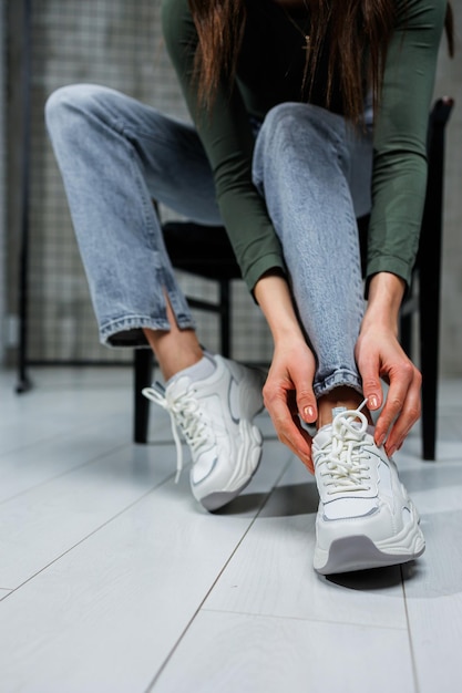 Closeup of female legs in jeans and shoes in fashionable sneakers closeup Women's everyday fashionable shoes