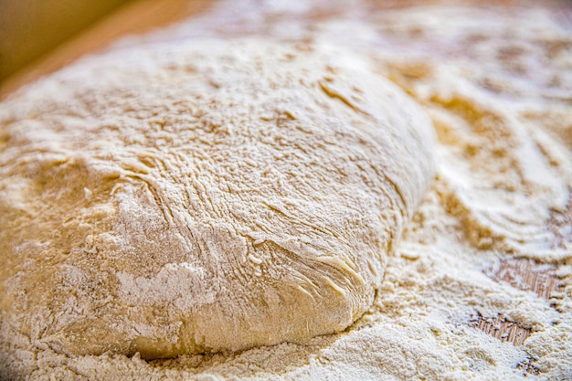 Photo closeup fermented doughs homemade macro selective focus raw dough texture backdrop texture of rolled dough background of the dough for baking fresh raw dough for pizza or bread baking