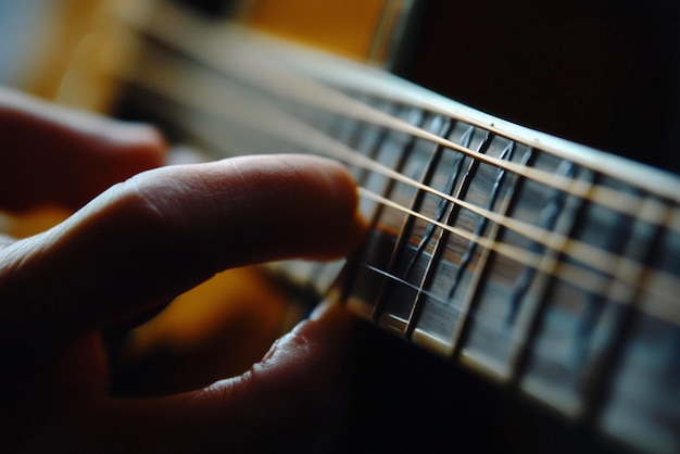 Photo closeup of fingers fretting a guitar