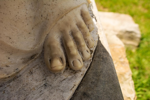 Closeup of the fingers of the sculpture the sculpture stands on the stone